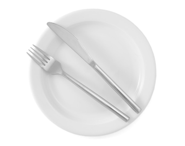 Plato blanco vacío con tenedor y cuchillo aislado en blanco