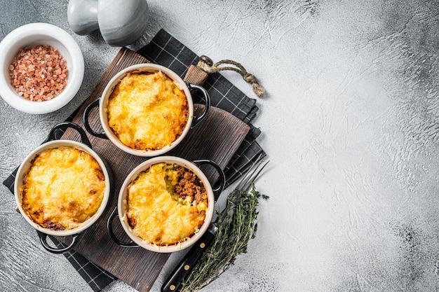 Plato británico Shepherd's pie con carne molida, puré de patata y costra de queso cheddar. Fondo blanco. Vista superior. Copie el espacio.