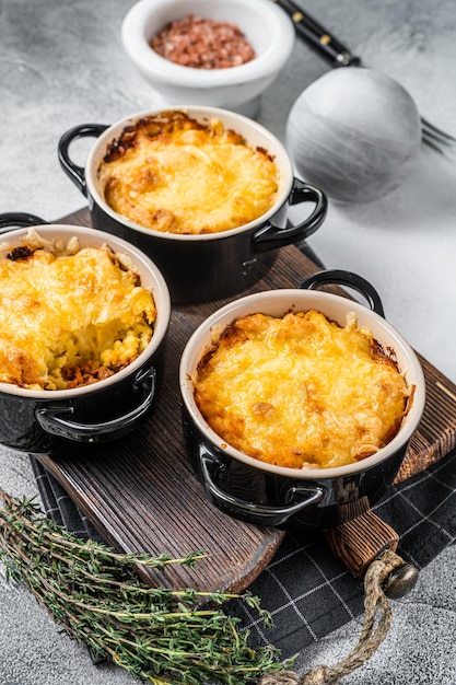 Plato británico Shepherd's pie con carne molida, puré de patata y costra de queso cheddar. Fondo blanco. Vista superior.