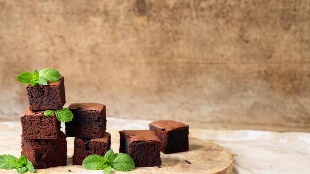 Un plato de brownies con hojas de menta sobre una mesa de maderaIA generativa