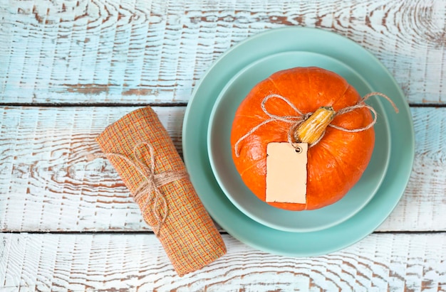 plato con calabaza y servilleta sobre mesa de madera azul