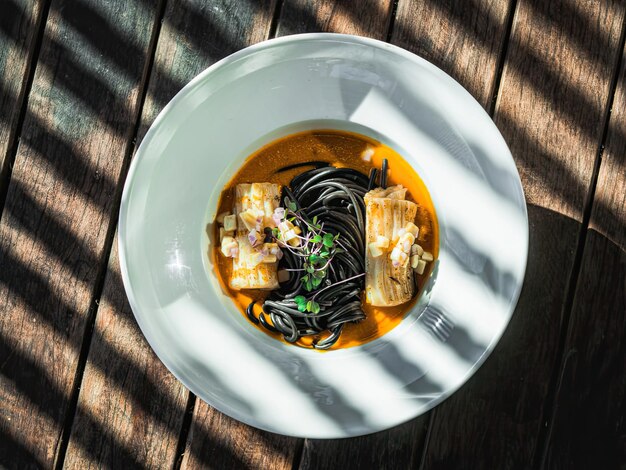 Un plato de calamares negros con salsa roja