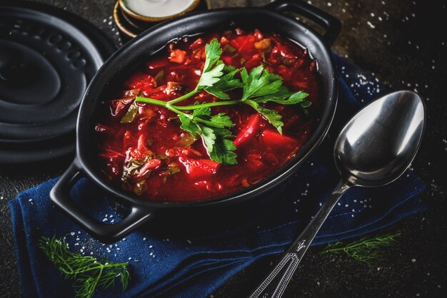 Plato caliente tradicional ruso ucraniano - sopa de borsch, con verduras, ajo, pan de centeno, sobre una mesa oscura