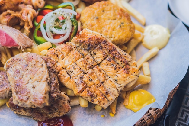 Plato de carne de comida griega grande con patatas y salsa.