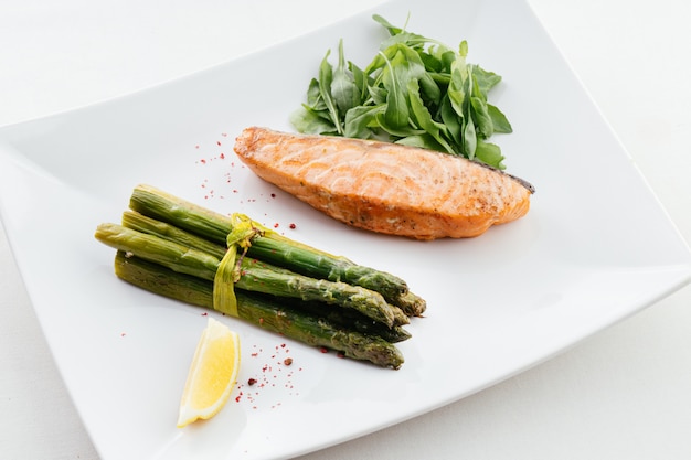 Plato de carne fresca con pescado y espárragos verdes