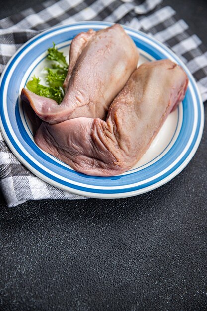 Un plato de carne con una hoja verde al lado.