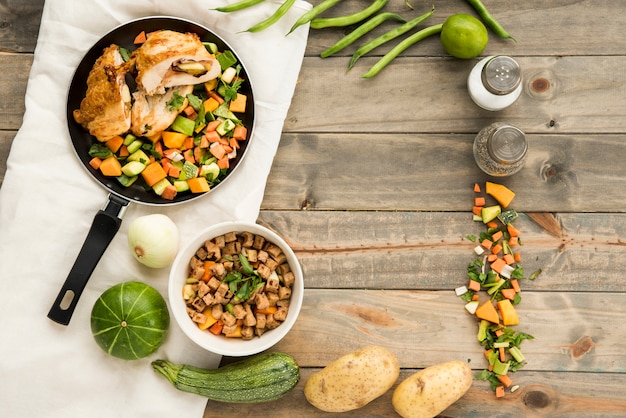 Foto plato con carne y verduras al lado de ingredientes.