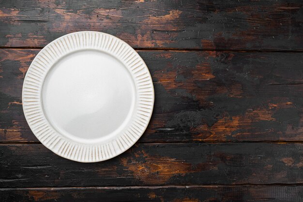 Plato de cena vacío con espacio de copia para texto o comida con espacio de copia para texto o comida, vista superior plana, sobre fondo de mesa de madera oscura vieja