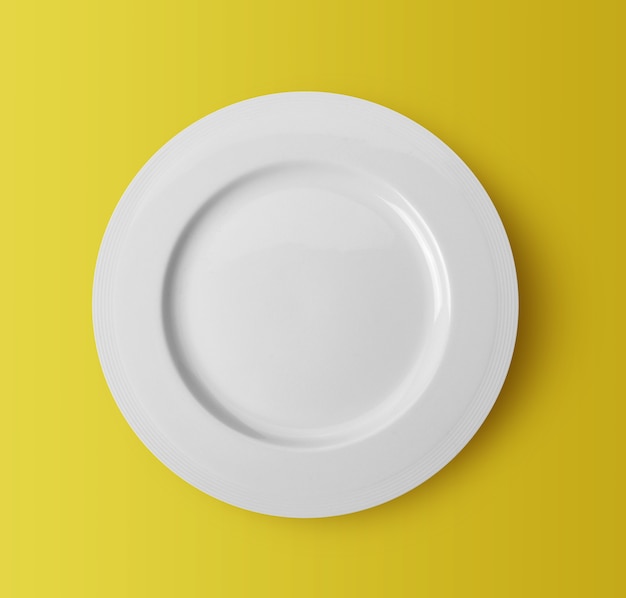 Plato de cerámica blanca sobre fondo amarillo