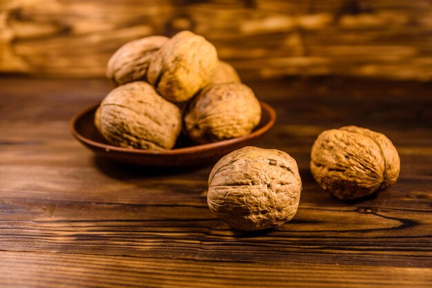 Plato de cerámica con nueces sobre una mesa de madera