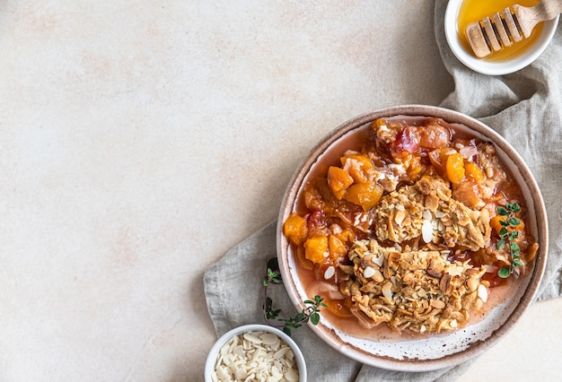 Plato de cerámica con sabroso crumble de ciruelas servido con helado de vainilla y hierbas