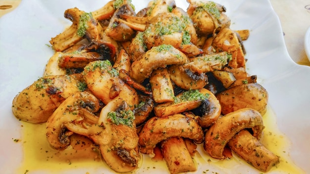 Un plato de champiñones con salsa de hierbas verdes