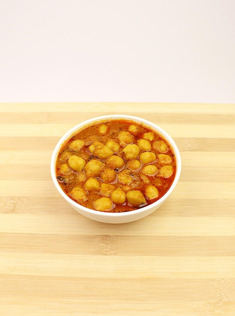 Un plato de Chhole masala está sobre una mesa de madera