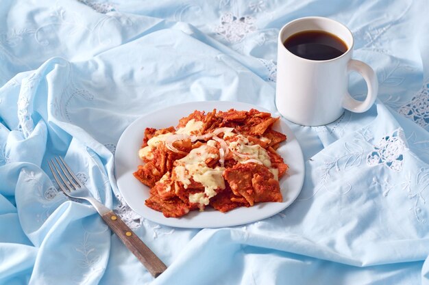 Plato de chilaquiles rojos sobre fondo rústico Plato tradicional mexicano