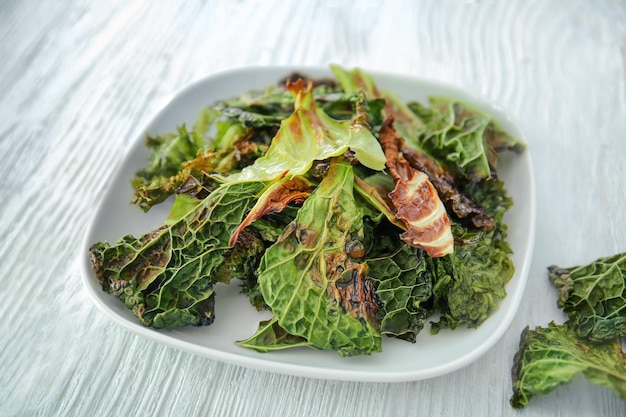 Plato con chips de lechuga en la mesa de madera