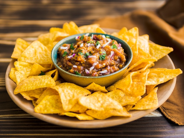 Foto plato de chips de nacho con salsa casera.