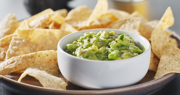 Plato de chips de tortilla de maíz con salsa de guacamole