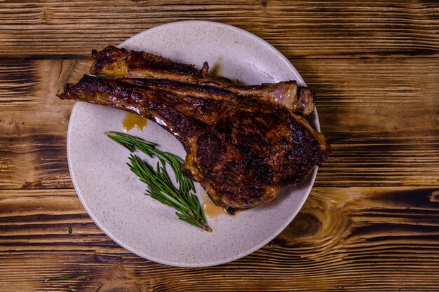 Plato con chuletón asado en la mesa de madera Vista superior