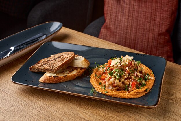 Plato clásico de aperitivo oriental: hummus de garbanzos con aceite de oliva blanco y salsa de verduras