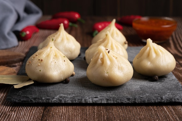 Un plato de cocina georgiana khinkali en una pizarra negra