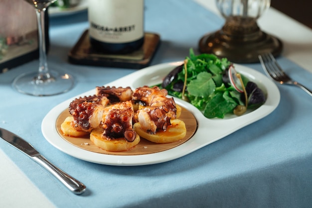 Plato de la cocina nacional española pulpo gallego con patata y ensalada verde