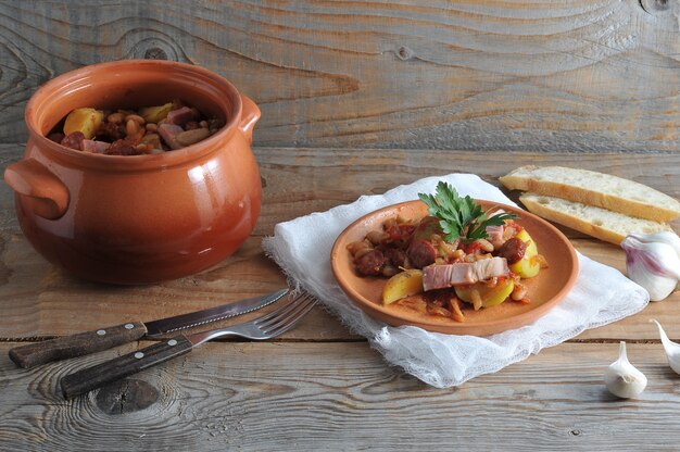 Plato cocinado en una olla con papas, frijoles, ahumado en una olla de barro