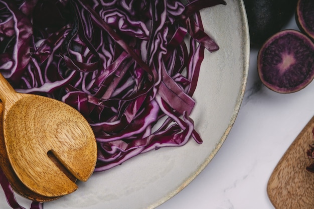 Foto plato con col lombarda cortada con cucharas de madera