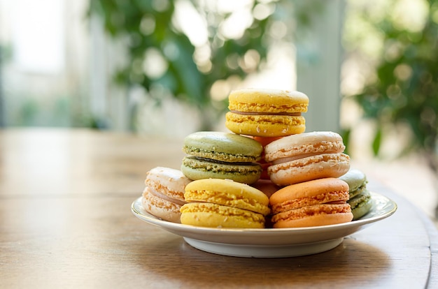 Un plato con coloridos pasteles de macarons para un delicioso desayuno francés en una habitación soleada