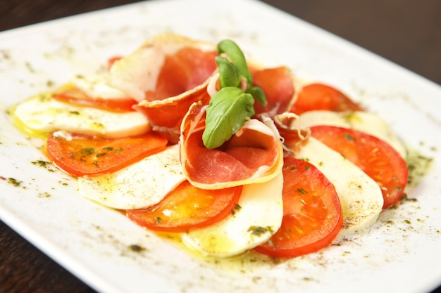 Plato combinado con queso mozarella y tomates con bonita albahaca verde