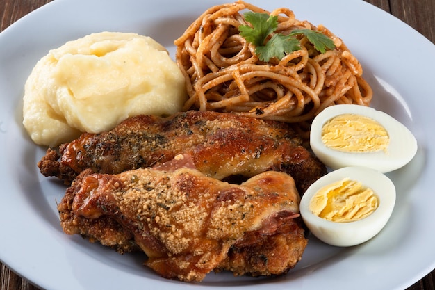 Plato de comida para el almuerzo Pasta con puré de pollo asado y huevos vista de cerca