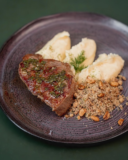 Un plato de comida con un bistec y una guarnición de puré de patatas.