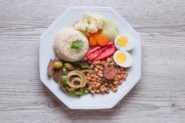 Plato de comida brasileña Frijoles, arroz, carne, huevos, ensalada.