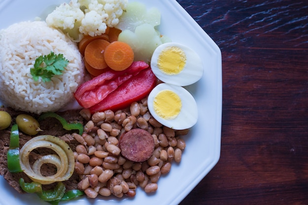 Plato de comida brasileña Frijoles, arroz, carne, huevos, ensalada.