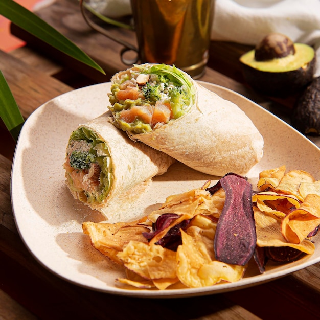 Foto un plato de comida con un burrito y papas fritas.