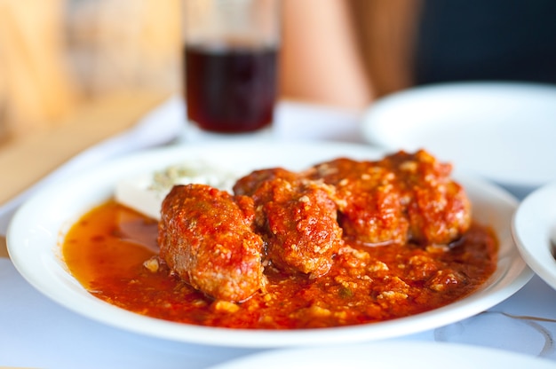 Foto plato con comida de carne en salsa de tomate.