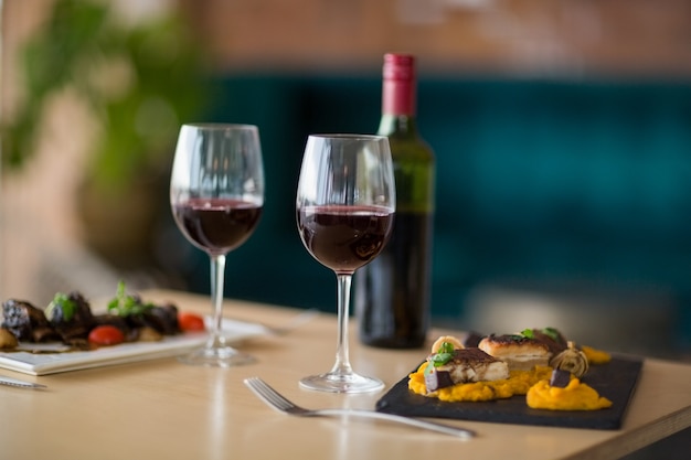 Plato de comida con copa de vino tinto