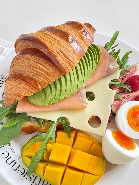 Un plato de comida con un croissant y huevos.