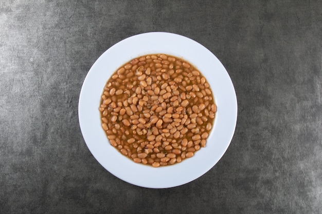 Plato de comida con frijoles en la mesa oscura. Vista superior