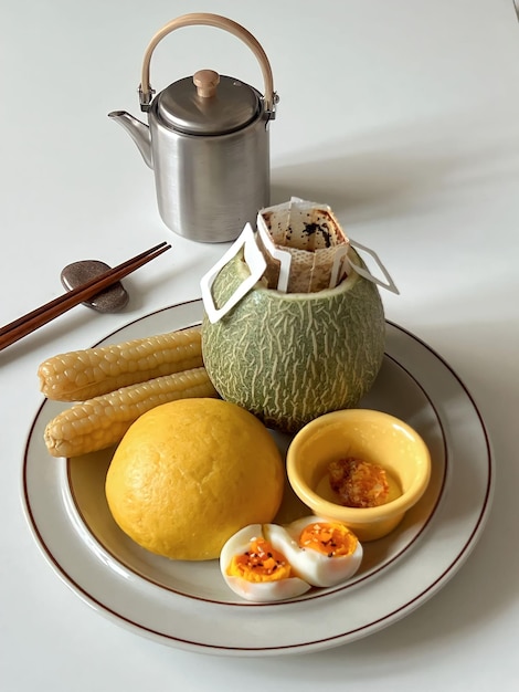 Un plato de comida con una fruta amarilla y una taza de té al lado.