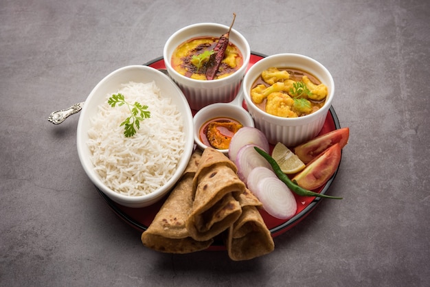 El plato de comida india o thali vegetariano incluye Dal Fry, arroz, chapati y un tipo de verdura con ensalada.