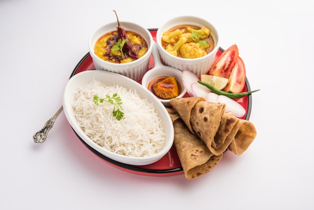 El plato de comida india o thali vegetariano incluye Dal Fry, arroz, chapati y un tipo de verdura con ensalada.