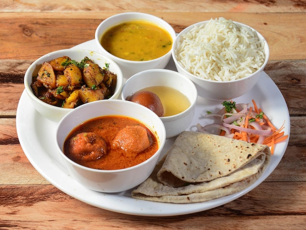 El plato de comida Indian Veg Kofta curry Thali consiste en una variedad de verduras, lentejas, platos dulces, bocadillos, etc. enfoque selectivo