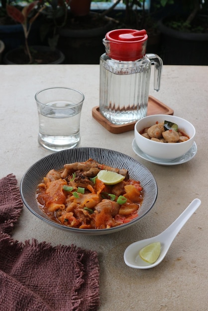 Un plato de comida con una jarra de agua y una toalla roja.