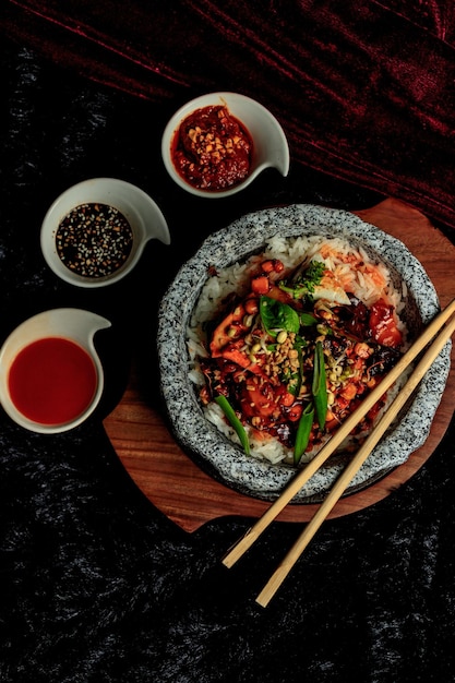 Un plato de comida con palillos y un plato de kimchi.