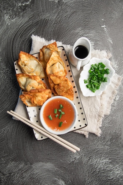 Un plato de comida con palillos y un plato de salsa.