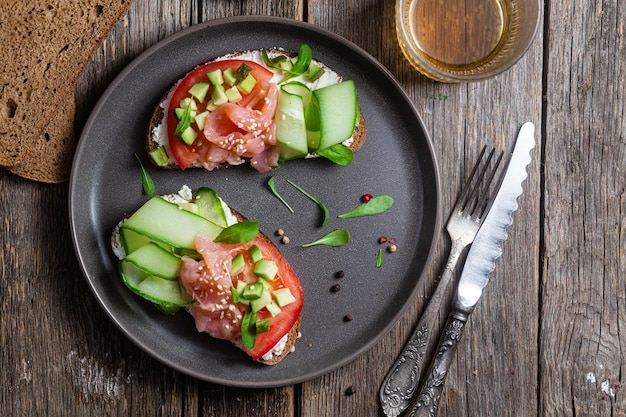 Un plato de comida con pepino, pepino y tomate.