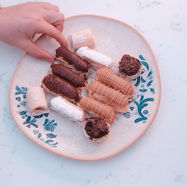 Foto un plato de comida con una persona sosteniendo un cuchillo y un plato con un pedazo de pastel en él