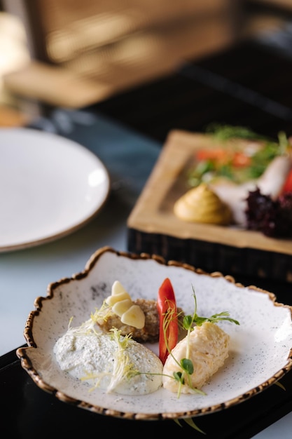 Un plato de comida con un plato blanco con un plato blanco que dice "pescado" en él