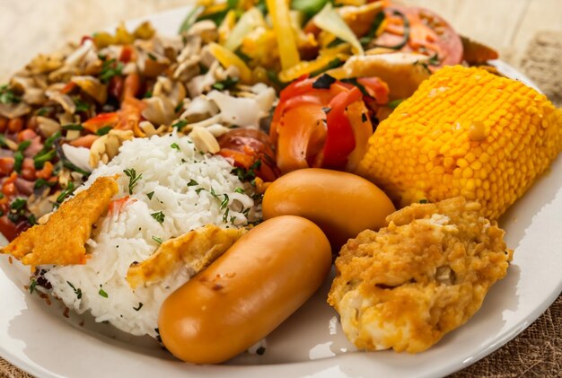 Un plato de comida que incluye camarones, arroz y verduras.