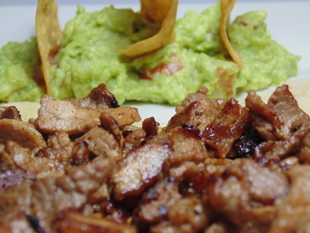 un plato de comida que incluye carne y aguacate y una ensalada